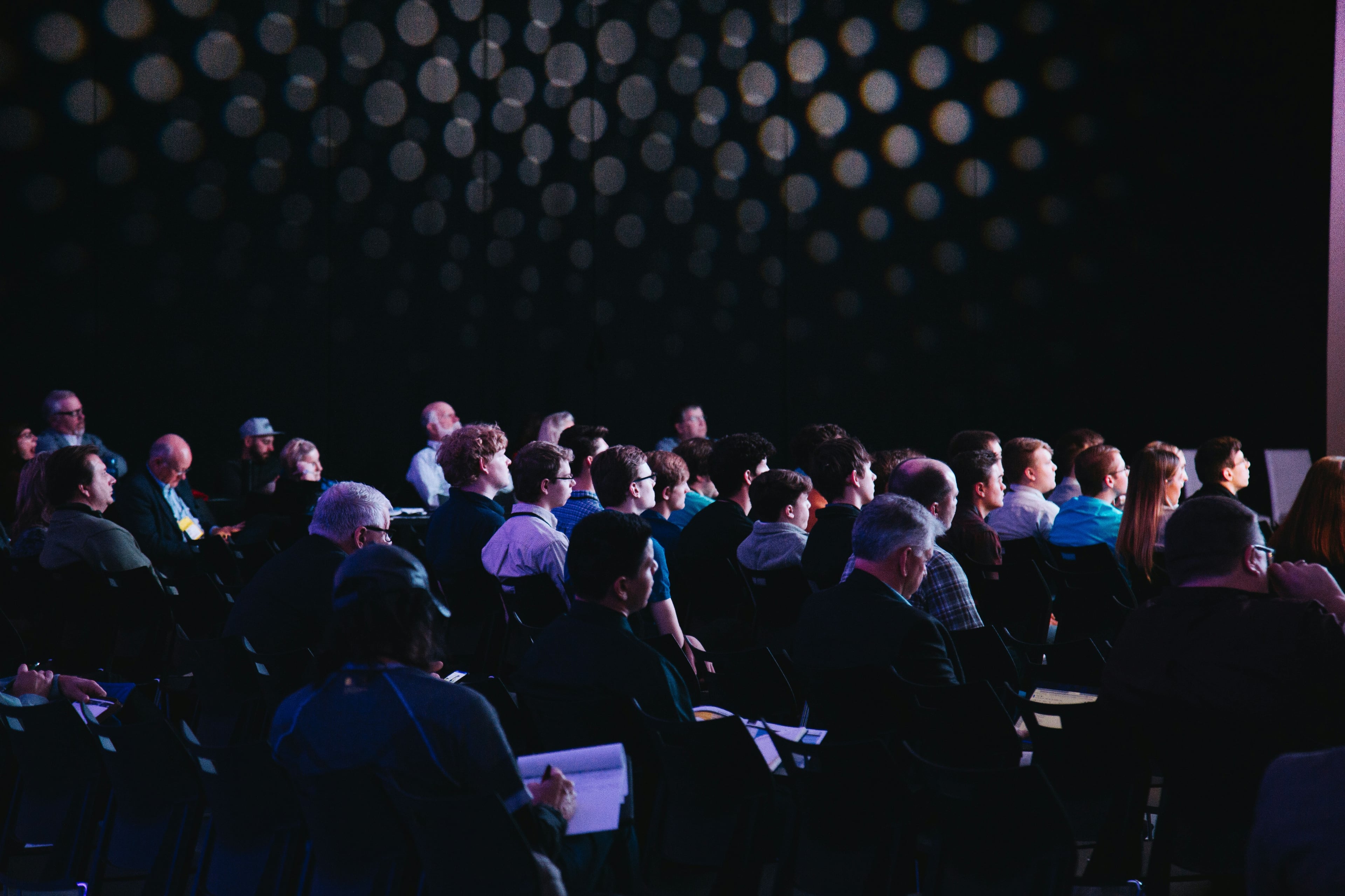 Decorative photograph of a conference hall used as a background.
