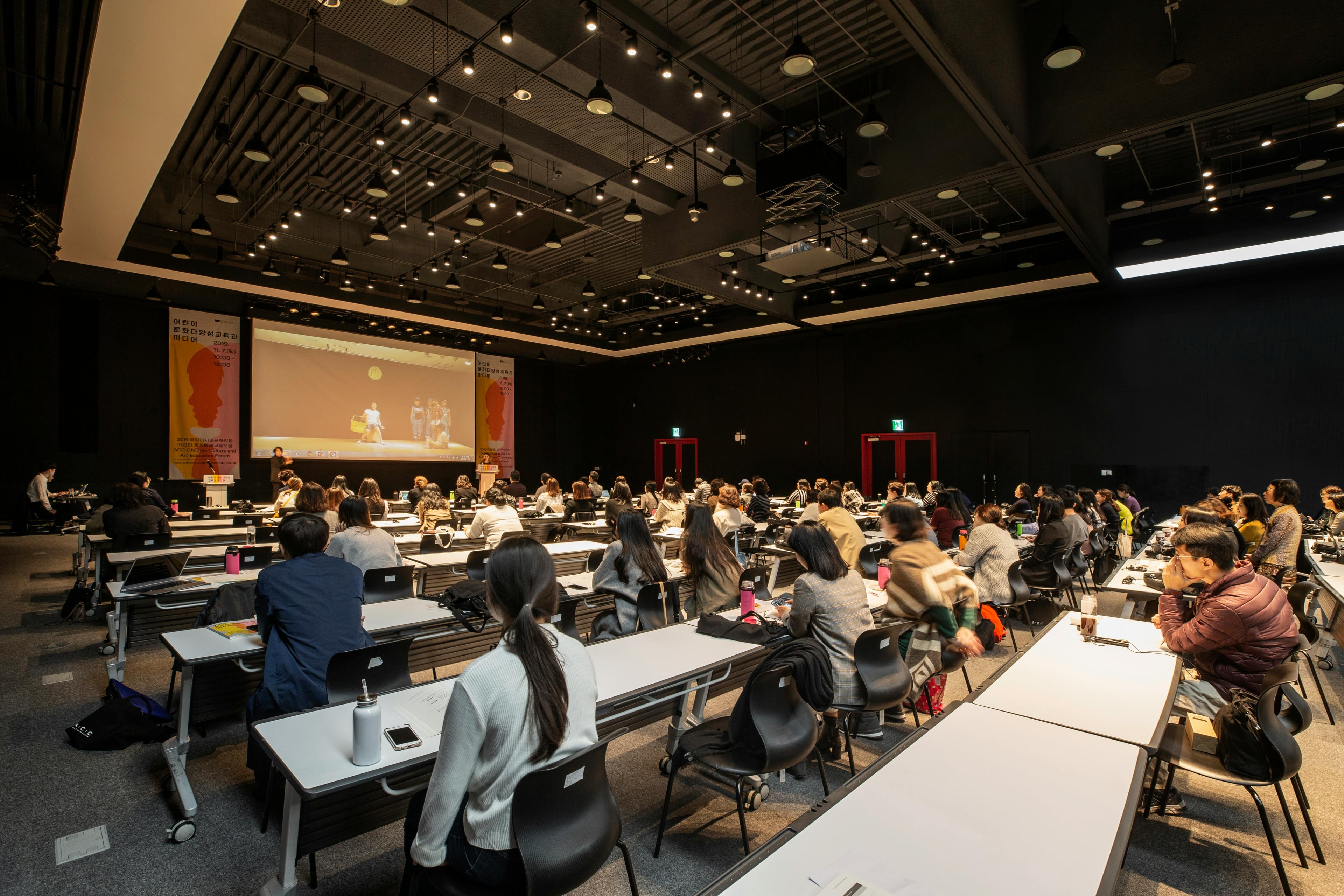 Decorative photograph of a conference hall used as a background.